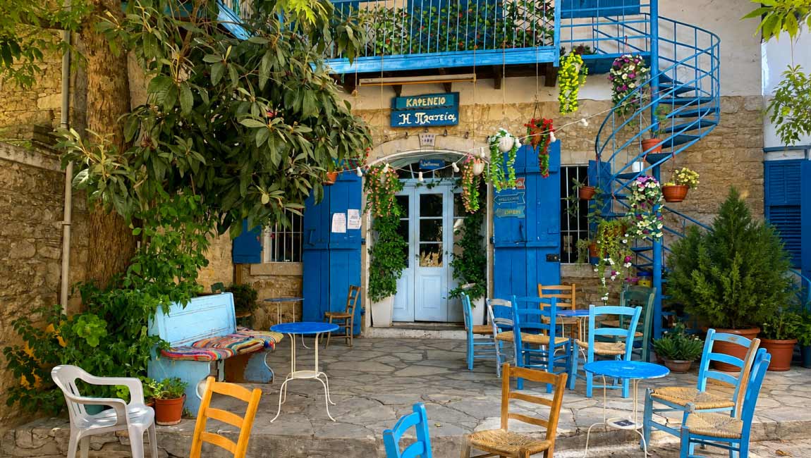 Traditional café with a stone facade and blue details in Afytos, Halkidiki.